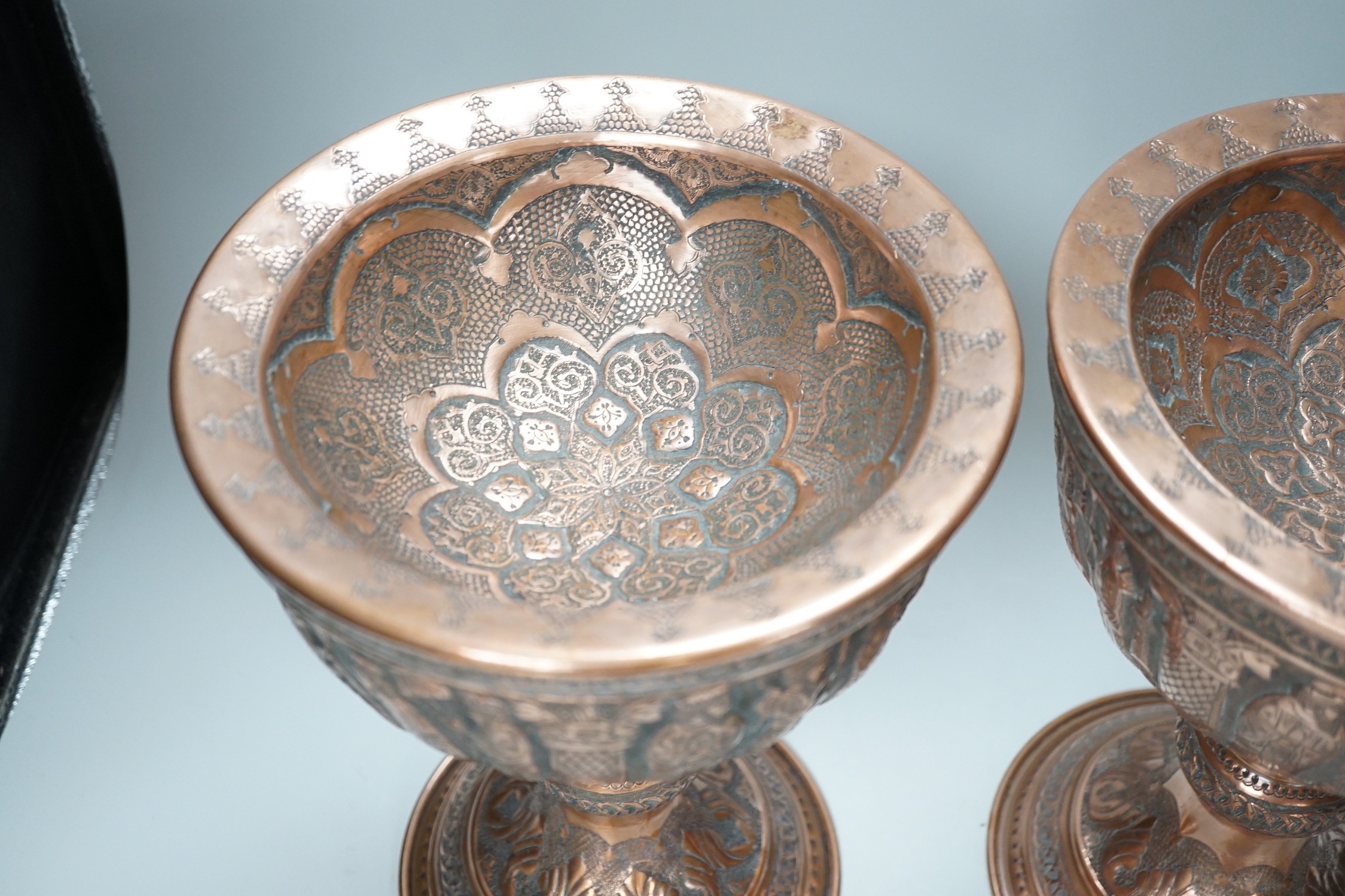 A pair of Persian copper figural decorated chalices, 27cms high